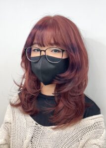 A creative pink brown base hairstyle featuring purple raccoon tail stripes on face-framing layers, blending Y2K nostalgia with modern vivid color techniques at Assort Osaka.