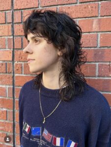 A voluminous curly wolf cut using the waterfall layering technique on natural 3A curls, showcasing bounce and face-framing texture at Assort Osaka.