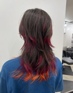 Deep black base hair with a "Volcanic" red and orange dip-dye.